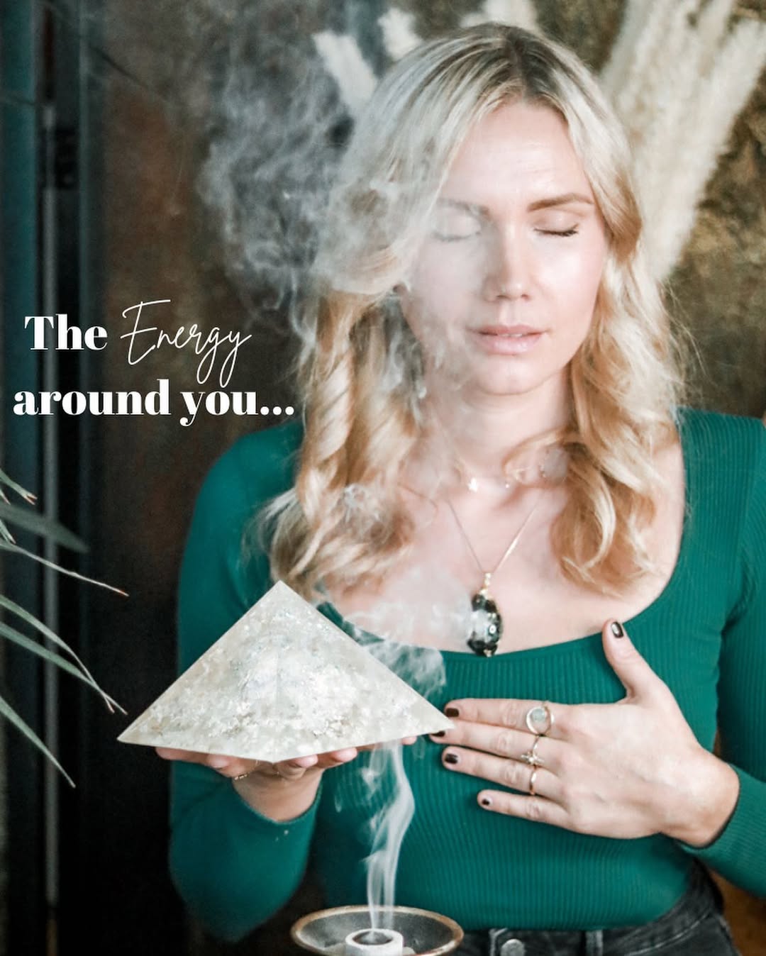 Frau hält Pranakristall Pyramide mit Räucherstäbchen